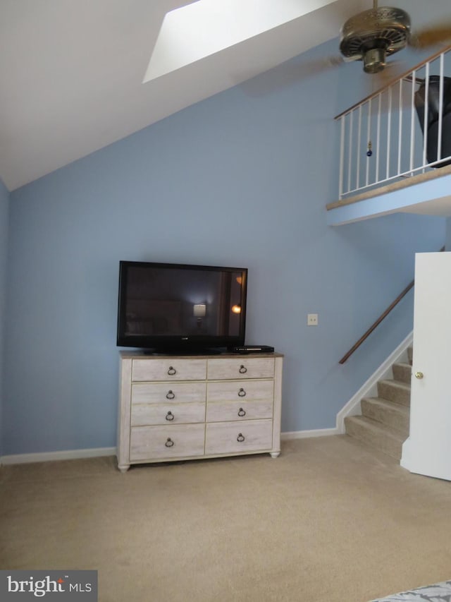 living area featuring carpet, stairs, baseboards, and vaulted ceiling
