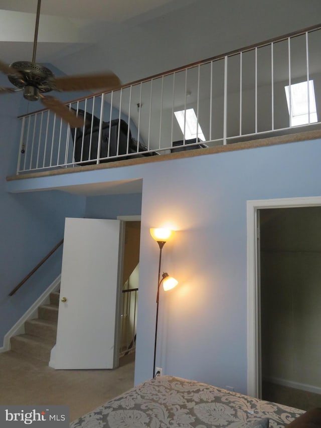 staircase with ceiling fan and a high ceiling