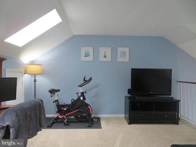 workout room with vaulted ceiling, a skylight, carpet flooring, and baseboards