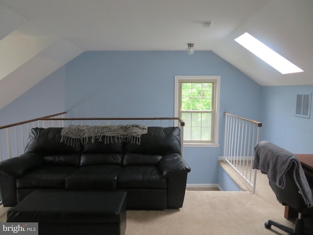 living area featuring a skylight, lofted ceiling, carpet flooring, and baseboards
