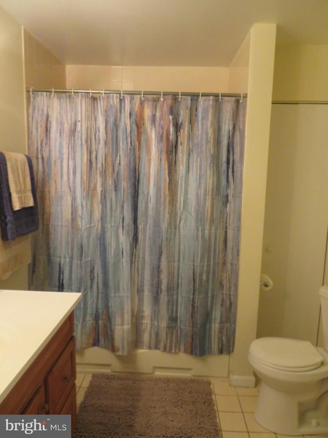 full bath with tile patterned floors, toilet, vanity, and shower / bath combo with shower curtain