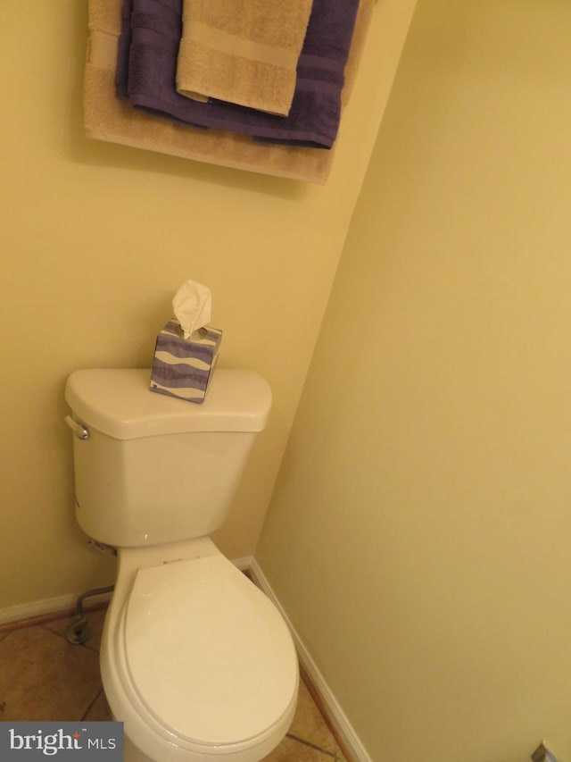bathroom featuring baseboards, toilet, and tile patterned flooring