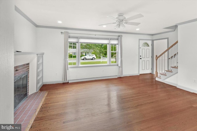 101 Flower, Mount Airy, MD 21771 - unfurnished living room featuring crown molding, wood finished floors, a brick fireplace, a ceiling fan, and stairs