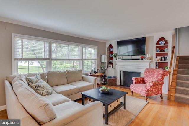 3663 Trinity, Alexandria, VA 22304 - living area with wood finished floors, a fireplace with flush hearth, stairs, built in features, and crown molding