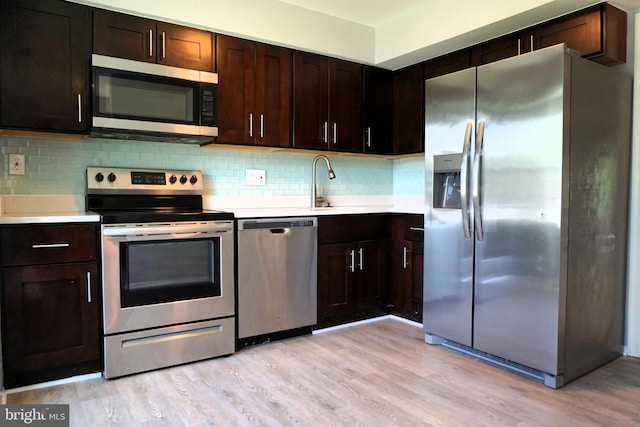3506 Split Rail Ln, Ellicott City, MD 21042 - kitchen featuring appliances with stainless steel finishes, light countertops, light wood-style floors, and tasteful backsplash