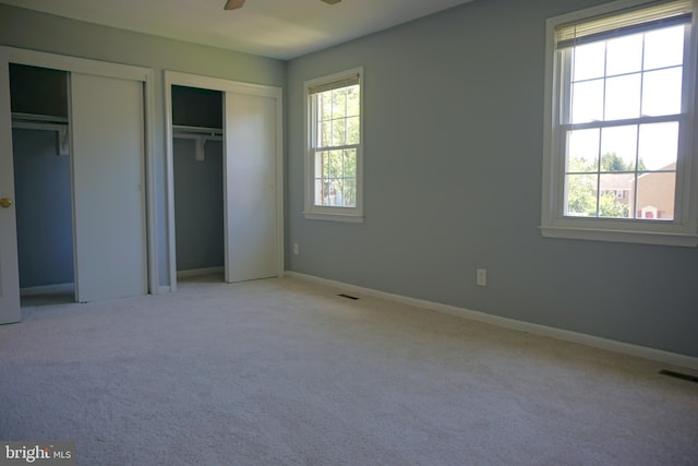 3506 Split Rail Ln, Ellicott City, MD 21042 - unfurnished bedroom featuring multiple closets, multiple windows, and light colored carpet