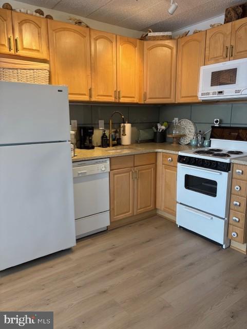 9415 Pacific Ave Unit 43, Margate City, NJ 08402 - kitchen featuring white appliances, a sink, light wood-style floors, and light countertops