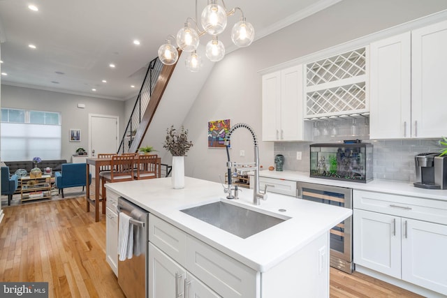 kitchen with dishwasher, crown molding, a sink, backsplash, and beverage cooler