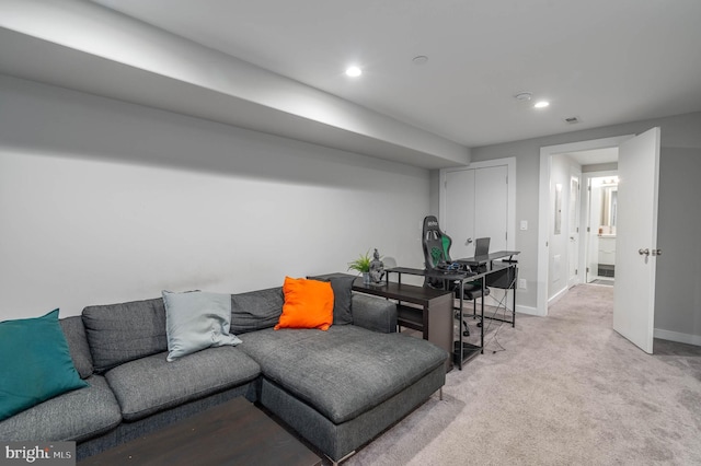 living area with baseboards, recessed lighting, light colored carpet, and a desk