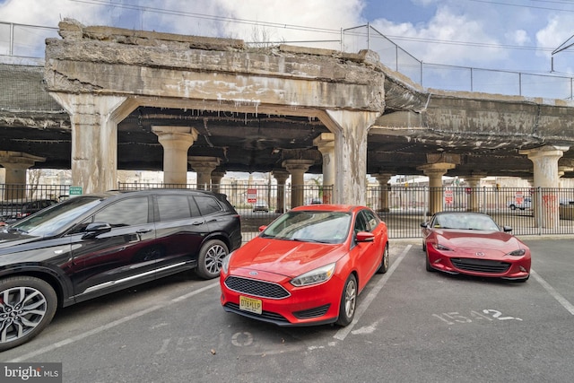 view of vehicle parking featuring fence