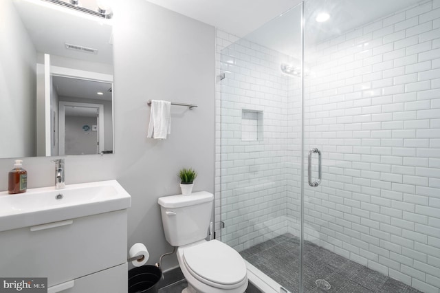 full bathroom featuring toilet, a shower stall, and vanity