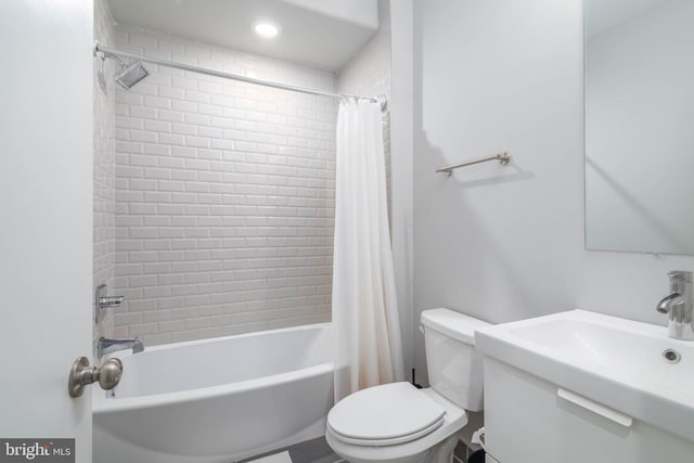 bathroom featuring toilet, shower / bath combination with curtain, and a sink