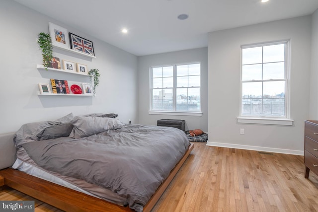 bedroom featuring wood finished floors, recessed lighting, and baseboards