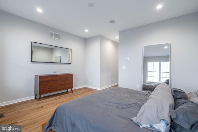 bedroom with wood finished floors, recessed lighting, and baseboards