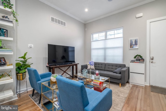 living room featuring wood-type flooring, ornamental molding, and recessed lighting