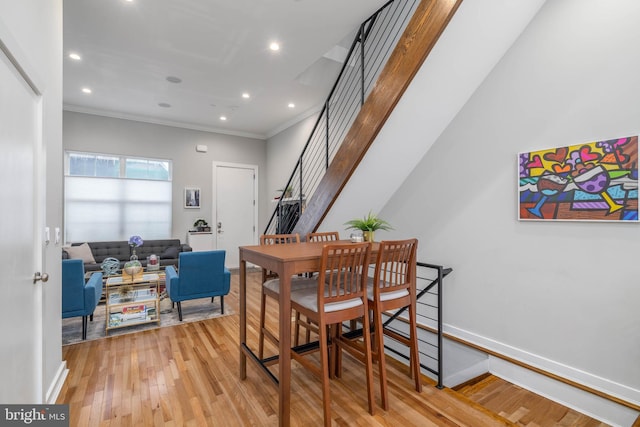 dining room featuring light wood-style floors, ornamental molding, stairs, recessed lighting, and baseboards