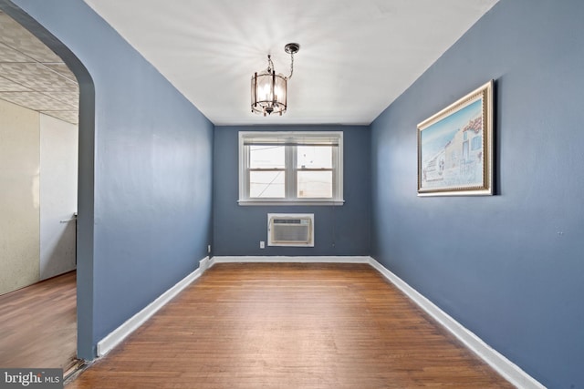 6602 Revere St, Philadelphia, PA 19149 - unfurnished room featuring a wall mounted AC, wood finished floors, arched walkways, and a chandelier