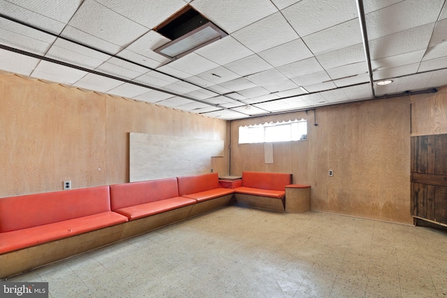 6602 Revere St, Philadelphia, PA 19149 - unfurnished living room with tile patterned floors, wooden walls, and a drop ceiling