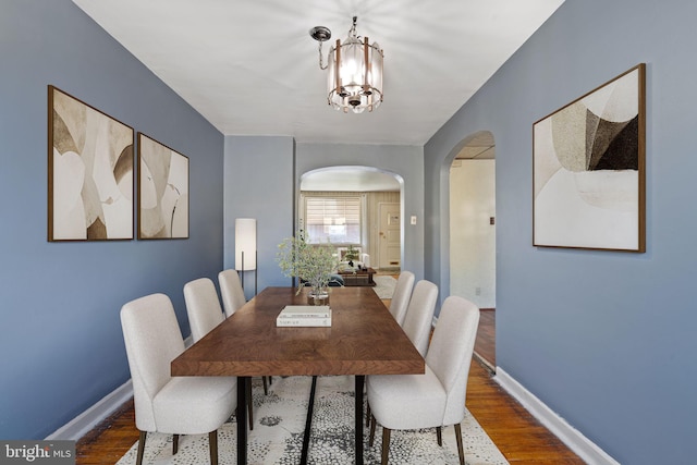 6602 Revere St, Philadelphia, PA 19149 - dining room featuring arched walkways, wood finished floors, a chandelier, and baseboards