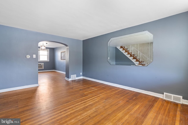 6602 Revere St, Philadelphia, PA 19149 - empty room with arched walkways, wood finished floors, baseboards, and a wall mounted air conditioner