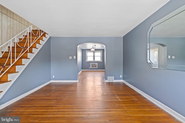 6602 Revere St, Philadelphia, PA 19149 - unfurnished room with wood finished floors, arched walkways, a wall mounted air conditioner, and stairs