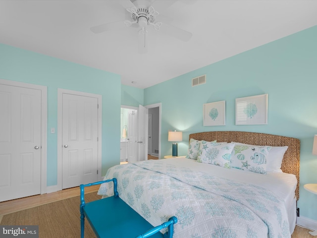 32561 Heron Cir Unit 13, Bethany Beach, DE 19930 - bedroom featuring wood finished floors, baseboards, a ceiling fan, and ensuite bathroom