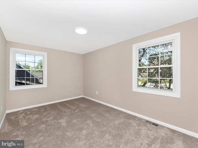 empty room featuring carpet and baseboards