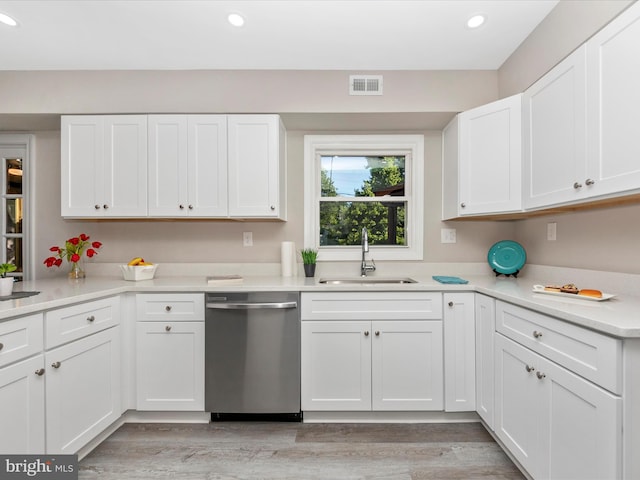 kitchen featuring dishwasher, a sink, recessed lighting, white cabinetry, and light wood-style floors