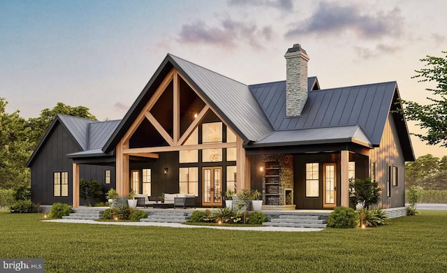 back of house with french doors, a standing seam roof, a chimney, and metal roof