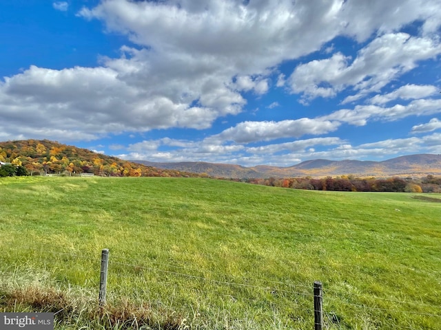 view of mountain backdrop with rural landscape