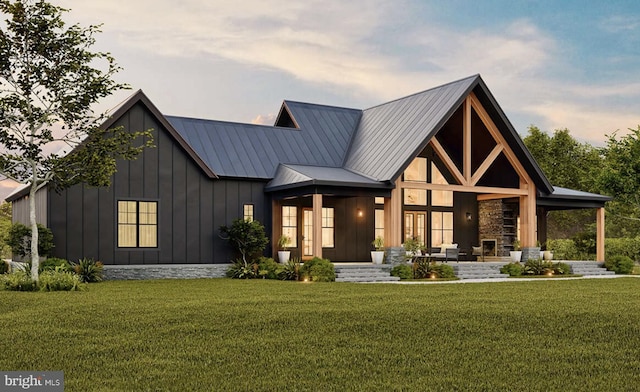 view of front of property with board and batten siding, a front lawn, metal roof, and an outdoor living space
