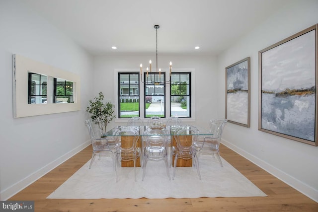 dining space with a chandelier, baseboards, wood finished floors, and recessed lighting