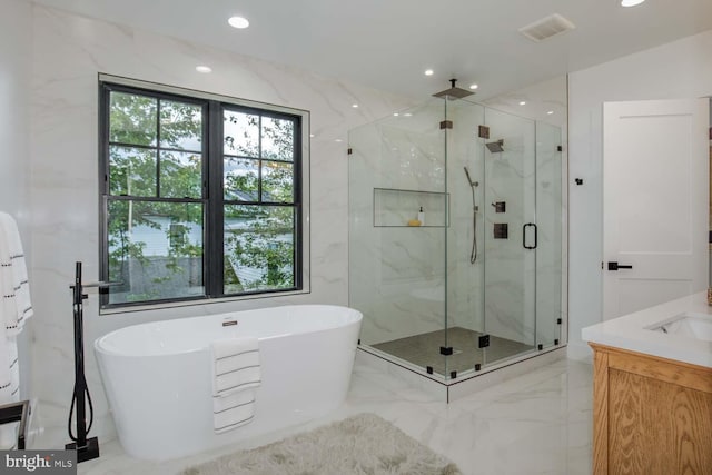 bathroom with a marble finish shower, a soaking tub, marble tiled floors, recessed lighting, and vanity