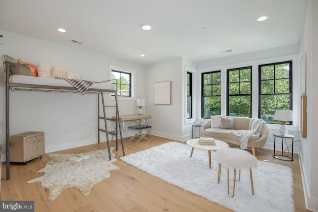 living room featuring baseboards, wood finished floors, and recessed lighting