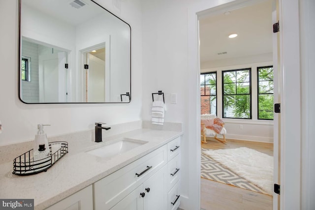 bathroom featuring vanity, wood finished floors, and recessed lighting