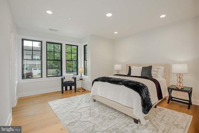 bedroom featuring baseboards, wood finished floors, and recessed lighting