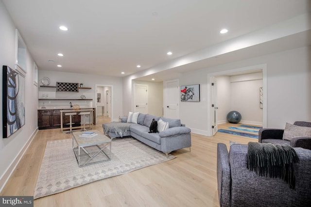 living area with light wood-style floors, recessed lighting, and baseboards