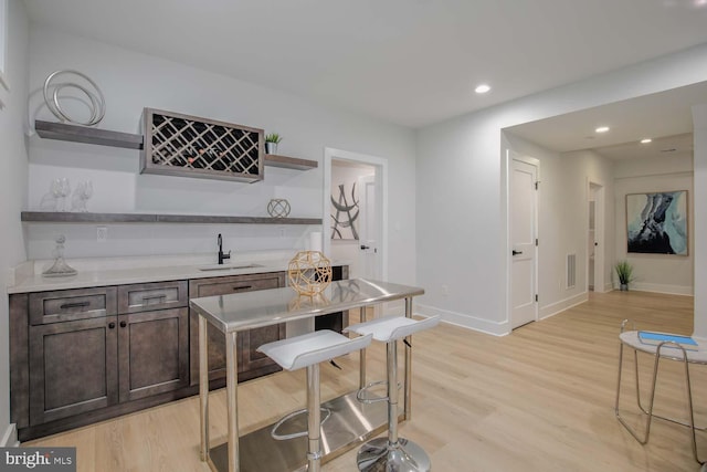 indoor dry bar featuring light wood-style floors, baseboards, and recessed lighting