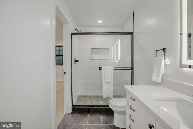 full bath featuring a stall shower, toilet, vanity, and recessed lighting