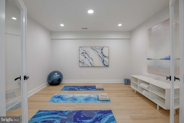 exercise room featuring wood finished floors, french doors, baseboards, and recessed lighting
