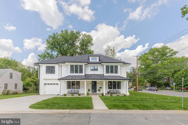 view of front of home with a porch, a standing seam roof, concrete driveway, a garage, and a front yard