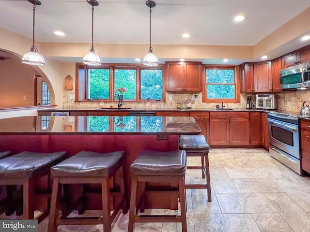 500 Newport Cir, Langhorne, PA 19053 - kitchen featuring stainless steel appliances, a sink, a kitchen bar, decorative backsplash, and recessed lighting