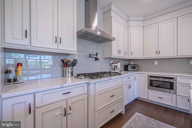 232 Cobblestone Ln, Bethlehem, PA 18020 - kitchen with wall chimney range hood, stainless steel gas cooktop, white cabinets, and dark wood-style flooring