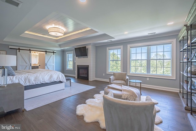 232 Cobblestone Ln, Bethlehem, PA 18020 - bedroom featuring ornamental molding, baseboards, a tray ceiling, a barn door, and dark wood-style flooring