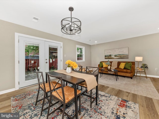 dining room with a chandelier, baseboards, wood finished floors, and french doors