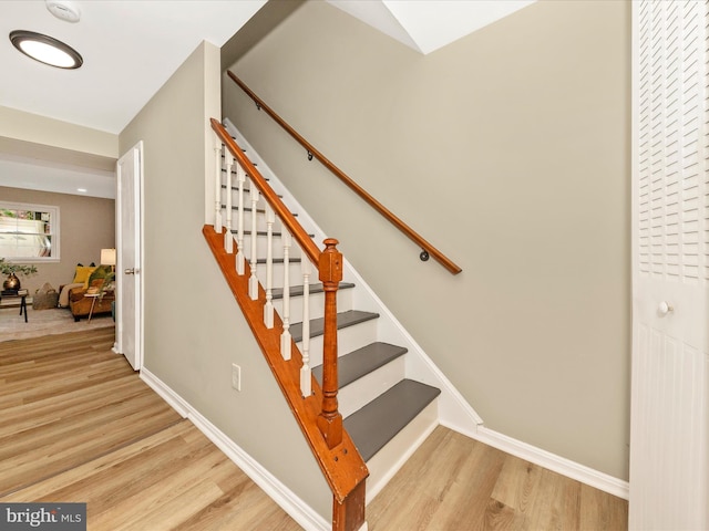 staircase with wood finished floors and baseboards
