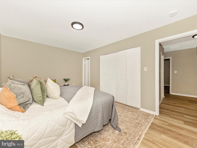 bedroom featuring light wood-style floors, a closet, and baseboards