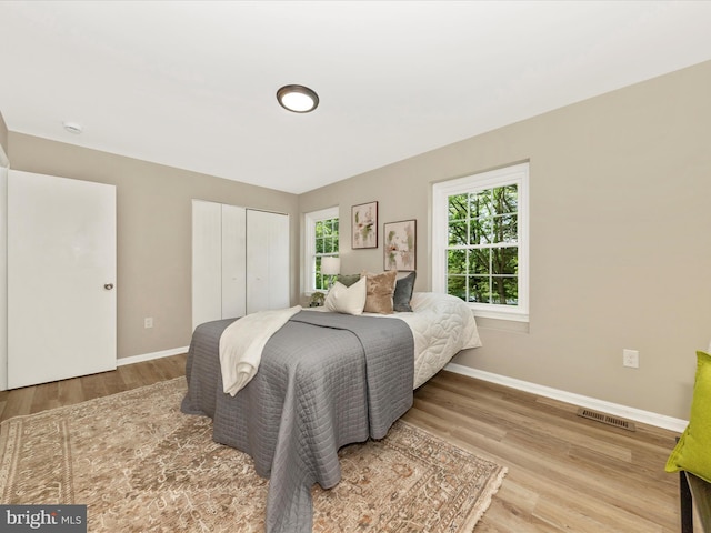 bedroom featuring wood finished floors, a closet, and baseboards