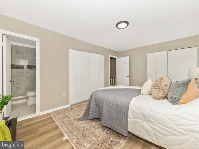 bedroom with multiple closets, connected bathroom, light wood-type flooring, and baseboards