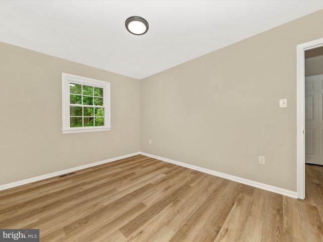 unfurnished room with light wood finished floors and baseboards